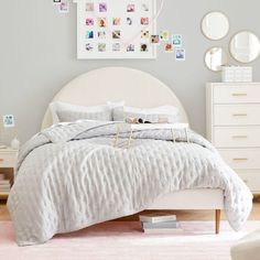 a white bed sitting in a bedroom on top of a pink rug