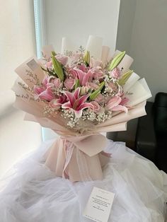 a bouquet of pink flowers sitting on top of a white table next to a mirror