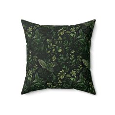 a green pillow with leaves on it, against a white background and the bottom half is black