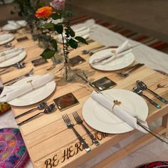 the table is set with white plates and silverware