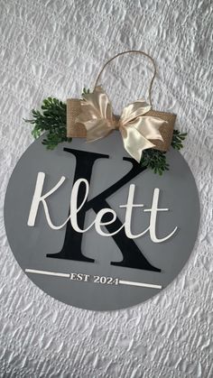 a sign that says klett on it with a bow hanging from the front