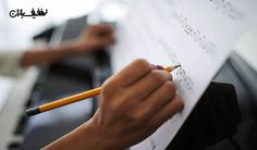 someone writing on a piece of paper while another person is holding a pencil in their hand