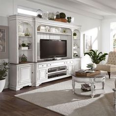 a living room filled with furniture and a flat screen tv on top of a white entertainment center