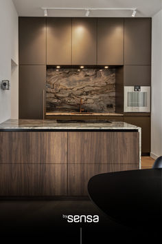 a modern kitchen with marble counter tops and wooden cabinetry is featured in the ad for sensea