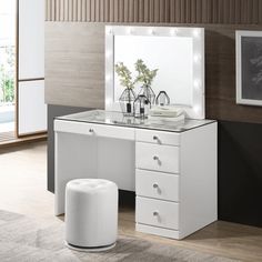 a white vanity with lighted mirror and stool