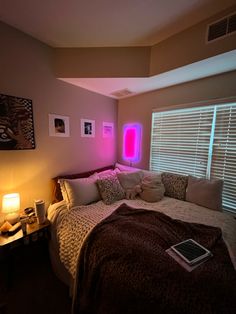 a bedroom with a bed, lamp and pictures on the wall