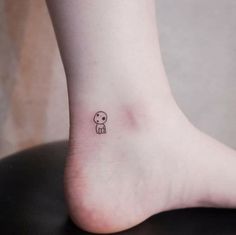 a small tattoo on the foot of a person's leg, with an image of a dog