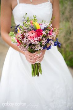 a woman holding a bouquet of flowers in her hands