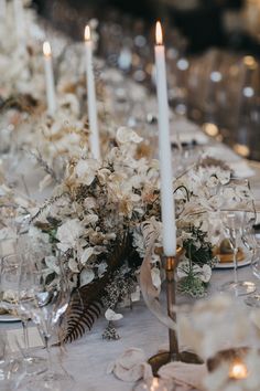 the table is set with white flowers and candles