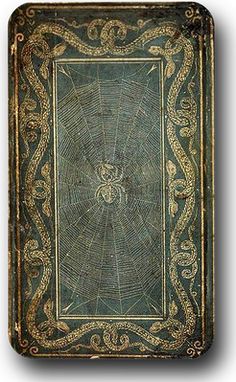 an old book with spider webs on the front and back cover, in gold trimming