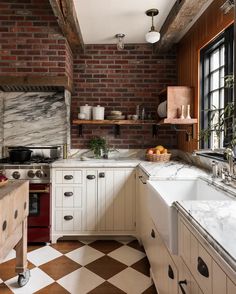 a kitchen with brick walls and white cabinets