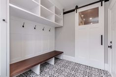 a bench in the middle of a room with white walls and black and white flooring