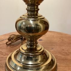 a metal lamp sitting on top of a wooden table next to a cordless phone