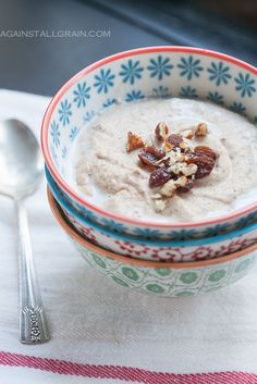 a bowl filled with oatmeal and nuts on top of a table next to a spoon