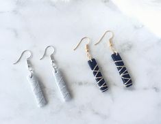 three different types of earrings on a marble surface