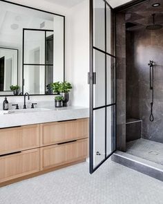 a bathroom with marble counter tops and wooden cabinets, along with a walk in shower