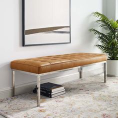 a bench sitting in the corner of a room next to a potted plant and books