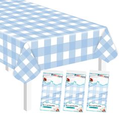 a blue and white checkered table cloth next to three place cards on a stand