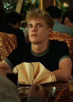 a young man sitting at a table in a restaurant