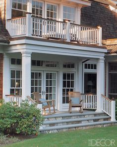 a large white house with porches and chairs