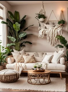 a living room filled with lots of plants next to a white couch and coffee table