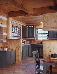 a kitchen with wood paneling and green cabinets in the center, along with a dining room table