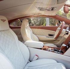 the interior of a luxury car with white leather