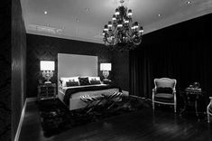 a black and white photo of a bedroom with chandelier