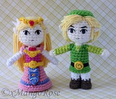 two crocheted dolls standing next to each other