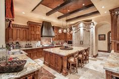 a large kitchen with marble counter tops and wooden cabinets, along with an island in the middle