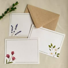 three cards with flowers on them are next to an envelope