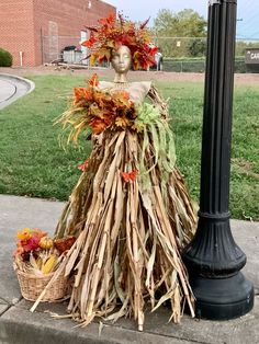 a mannequin made out of corn stalks and leaves on a street light pole