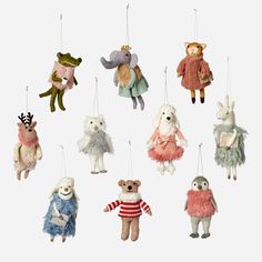 several stuffed animals hanging from strings on a white background in various colors and sizes,