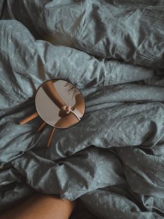 a person's reflection in a mirror on top of a bed with blue sheets