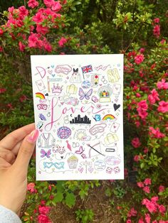 someone holding up a card with stickers on it in front of some pink flowers