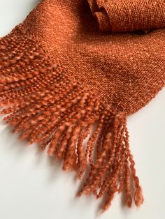 Stay warm and stylish with our handwoven scarf, made from a luxurious blend of burnt orange wool and bamboo. Measuring 7" wide and 77" long, with 3" long fringe, this scarf is the perfect size to wrap around your neck for added warmth and flair. Each scarf is handmade, ensuring that no two are exactly alike. The intricate weave and bold burnt orange color make this scarf a true statement piece that will add a touch of sophistication to any outfit. Not only is this scarf a fashionable and practic Fall Handwoven Alpaca Shawl, Brown Wool Shawl Scarf, Handwoven Alpaca Scarves For Fall, Fall Handwoven Alpaca Scarf, Fall Alpaca Handwoven Scarves, Woven Shawl Scarf For Fall, Handwoven Shawl For Fall, One Size, Handwoven Scarves For Fall, Handwoven One-size Shawl For Fall