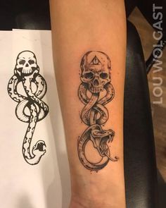 a skull and snake tattoo on the arm