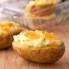 two baked potatoes sitting on top of a wooden table