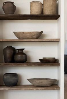 the shelves are filled with pots and bowls