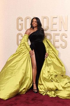 a woman in a black and yellow gown posing for the camera