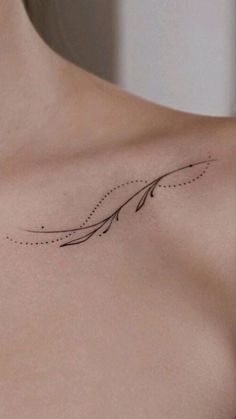 a woman's chest with an arrow tattoo on it