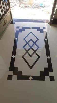 a black and white tile floor with an abstract design on it in front of a door