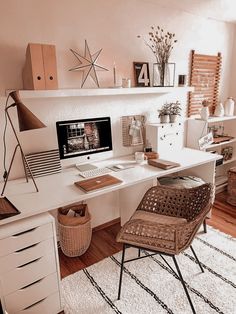 a white desk with a computer on top of it next to a chair and other items