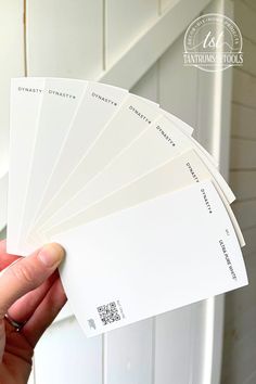 a person holding several white cards in their hand