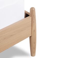 a wooden bed frame with white sheets in it