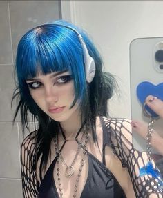 a woman with blue hair wearing headphones