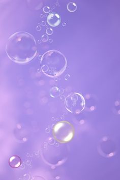 soap bubbles floating in the air on a purple background