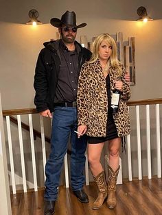 the man and woman are dressed up in cowboy hats, boots, and leopard coats