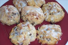 a red plate topped with muffins covered in icing