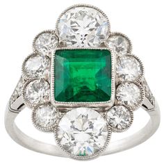 An Art Deco emerald and diamond ring, the square-cut emerald estimated to weigh 1.7 carats, accompanied by GCS Report stating to be of Colombian origin, vertically-set between two old European-cut diamonds each estimated to weigh approximately 1 carat and four smaller old-cut diamonds set on each side weighing approximately a further 1.2 carats, all mounted in platinum to D-section shank with diamond encrusted shoulders, head measuring 2x1.5cm, gross weight 5 grams, circa 1920. Finger size L Thi Art Deco Emerald, Art Deco Emerald Ring, Emerald And Diamond Ring, Antique Diamond Rings, Emerald Diamond Ring, Ring Art Deco, Art Deco Ring, Art Deco Jewelry, Emerald Ring